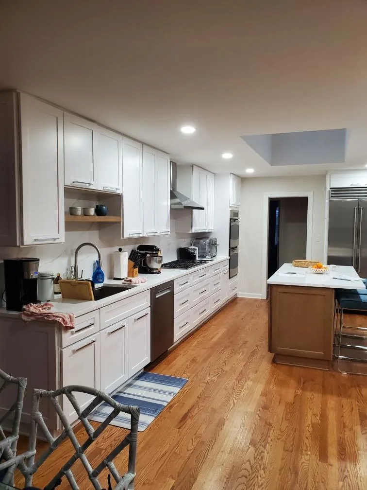 Custom kitchen with painted perimeter cabinetry and a wood island
